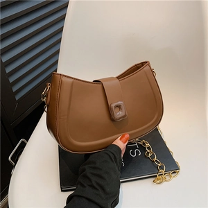 Minimalist brown crescent crossbody bag with golden chain and square buckle detail