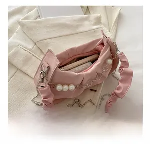 Top view of pale pink pleated crescent bag showing spacious interior with a smartphone