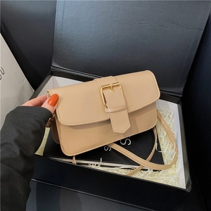 Sac sous les aisselles beige minimaliste avec boucle dorée dans un coffret cadeau noir