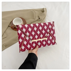 Détail de la pochette enveloppe tissée fuchsia et blanc avec finitions dorées