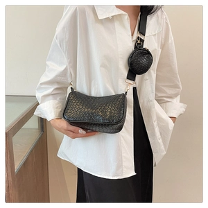 Détail du sac bandoulière tressé noir avec une petite pochette sur la bandoulière