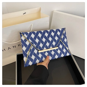 Détail de la pochette enveloppe géométrique bleu et blanc avec bordure dorée et fermoir