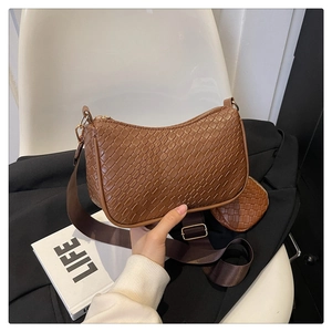 Gros plan sur un sac baguette marron tissé avec détail de petit porte-monnaie assorti