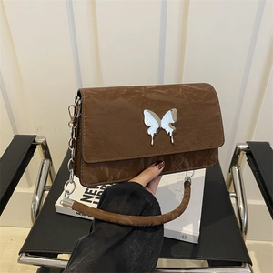 Brown distressed leather underarm bag with silver metal butterfly and chain strap