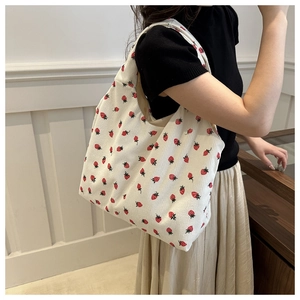 Detail of white corduroy tote bag with strawberry print and soft ribbed fabric texture