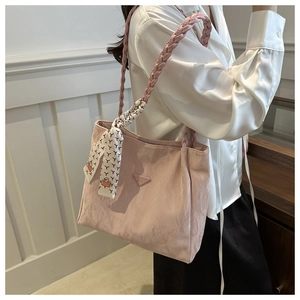 Detail van roze nylon tote tas met zijden sjaal en handvat van gevlochten leer