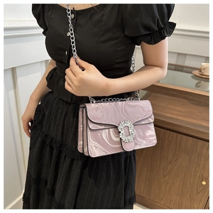 Close-up of pink marble pattern handbag with crystal buckle and silver chain strap