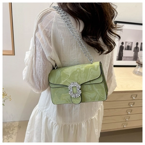 Detail of light green marble patterned handbag with silver chain strap and rhinestone buckle