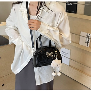 Detail of black bowling bag with silver butterfly buckle and white cloud charm