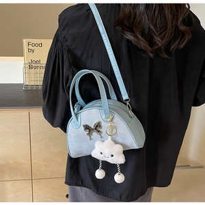Blue bowling shoulder bag with metal butterfly and cloud charm on model back