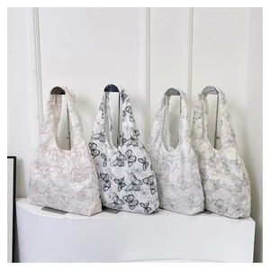 Detail of four embroidered butterfly tote bags in lace and organza on display stands