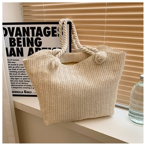 Macro shot of V-shaped weave texture and sturdy cotton rope handle on straw tote bag