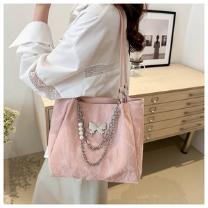 Borsa tote rosa a pieghe con ciondolo a farfalla e catena di perle indossata da modella