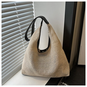 Détail du tissage de haute qualité et de la bandoulière en cuir noir du sac en paille