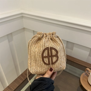 Sac seau en paille tressée beige avec écusson en cuir et fermeture à cordon