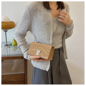 Close-up of khaki small square bag with marble texture and silver chain strap