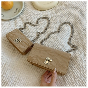 Detail of khaki pleated leather chain bags in two sizes with silver hardware accents