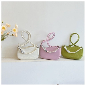 Close-up of three mini leather shoulder bags in cream, pink, and green with pearl chain detail