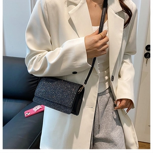 Detail einer funkelnden schwarzen Pailletten-Umhängetasche mit modernem Outfit