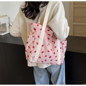 Détail du sac fourre-tout en velours rose à fraises avec poche latérale et sangle