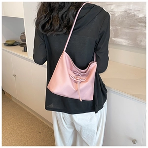 Detail view of pink ballet-style hobo bag with a soft pearlescent texture and bow drawstring
