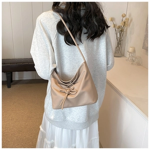 Detail of khaki ballet style bucket bag with drawstring bow and smooth texture