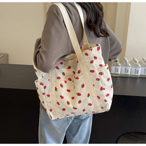 Détail du sac cabas en velours côtelé avec imprimés fraises et poches latérales