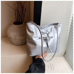 Vue détaillée du sac cabas argenté avec nœud décoratif et finition en cuir PU brillant