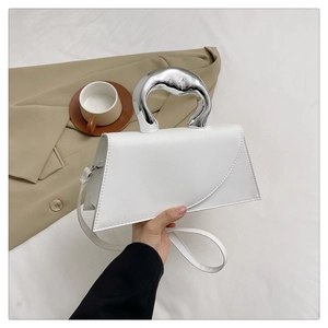 White trapezoid handbag featuring a unique silver metallic curved handle and sleek crossbody strap