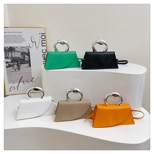 Detail of five-color handbags with sculptural silver handles and asymmetrical curved flaps