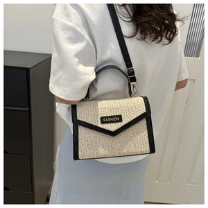 Détail du sac bandoulière en paille beige avec bordure en cuir noir et logo FASHION