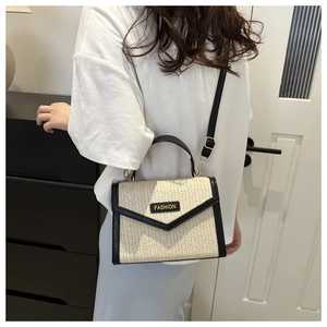 Détail d'un sac en paille tissée avec garniture en cuir et bandoulière réglable chic