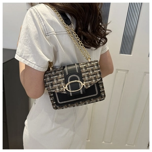 Detail of tweed and leather crossbody bag with gold chain strap on a model shoulder