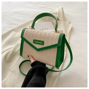Détail du sac à main tressé bicolore avec bordure en cuir vert et étiquette mode