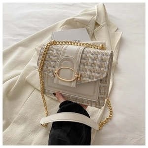 Detail van crème tweed en lederen crossbody tas met gouden metalen kettingriem