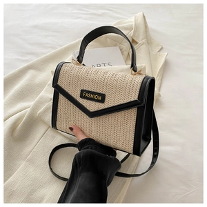 Détail du sac en paille tressée avec bordure en cuir noir et lettrage Fashion élégant