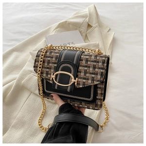 Detail van de bruin geruite tweed stof en gouden metalen gesp op de crossbody tas voor dames