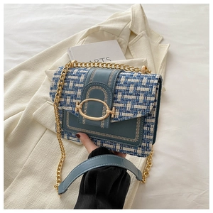 Detail van de blauw-witte tweed crossbodytas met gouden gesp en ketting schouderriem