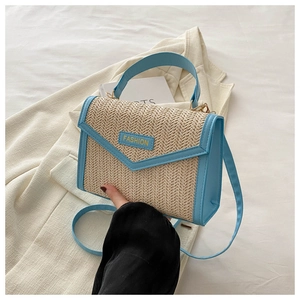 Détail du sac en paille à main avec bordure en cuir bleu clair et étiquette Fashion