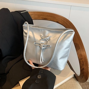 Silver balletcore bucket bag with metallic pearlescent finish and cross-tie ribbon detail
