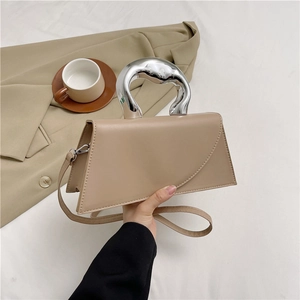 Elegant beige trapezoid handbag with fluid silver metal handle and leather shoulder strap