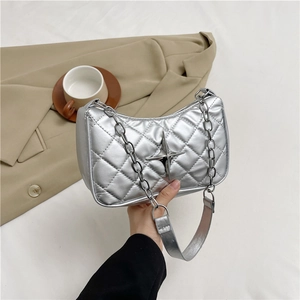 Silver quilted underarm bag with star detail and chain strap in a lifestyle setting