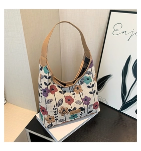 Close-up of floral jacquard tote bag with FASHION label and brown leather straps