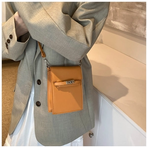 Détail de la pochette de téléphone en cuir orange avec fermoir argenté et bandoulière