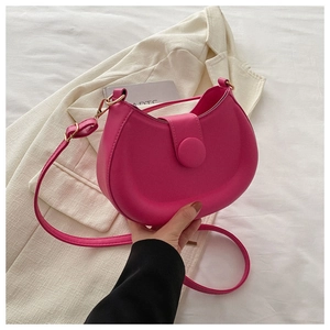 Detailed close-up of a rose red crescent crossbody bag with minimalist gold hardware finish