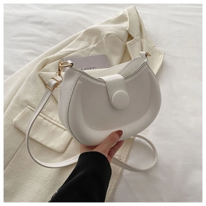 Close-up of a white semi-circular saddle bag with gold hardware and smooth leather finish