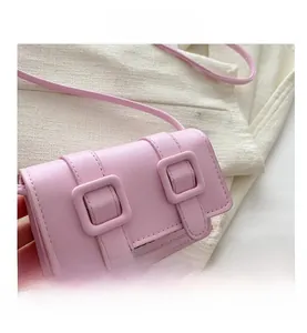 Nahaufnahme der rosa Mini-Umhängetasche mit dekorativen Schnallen und magnetischer Klappe