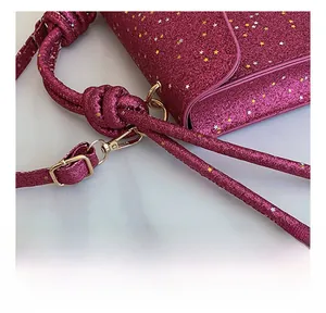Detail of rose pink handbag with gold star sequins and polished metallic buckle