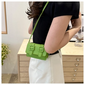 Detailansicht einer mini grünen Umhängetasche mit Doppel-Schnallen am Modell