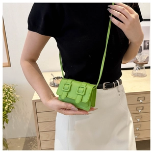 Detailansicht einer mini neongrünen Umhängetasche an der Taille in einem modernen Raum